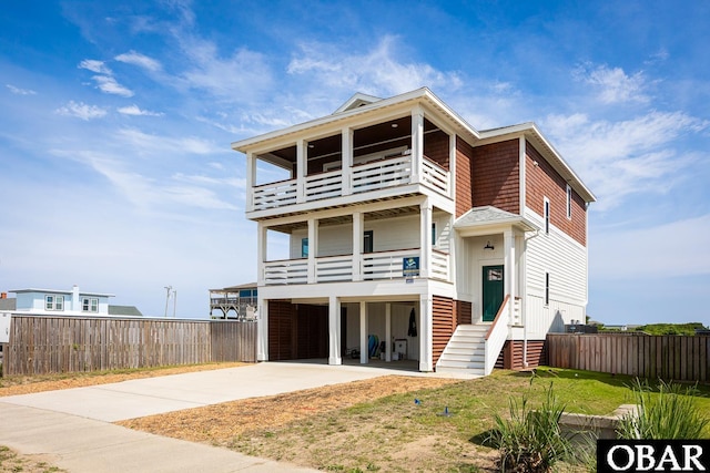 205 E Eckner St Lot # 17, Kitty Hawk, NC 27949 - view of front of home with a balcony, driveway, a carport, and board and batten siding