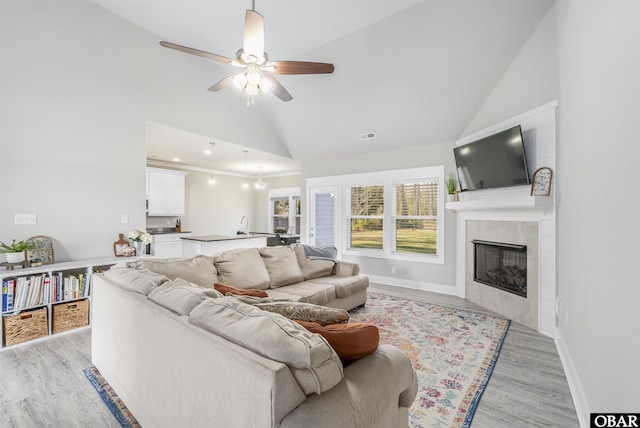 102 Keeter Barn Rd, Camden, NC 27976 - living room featuring high vaulted ceiling, baseboards, light wood-style floors, ceiling fan, and a fireplace