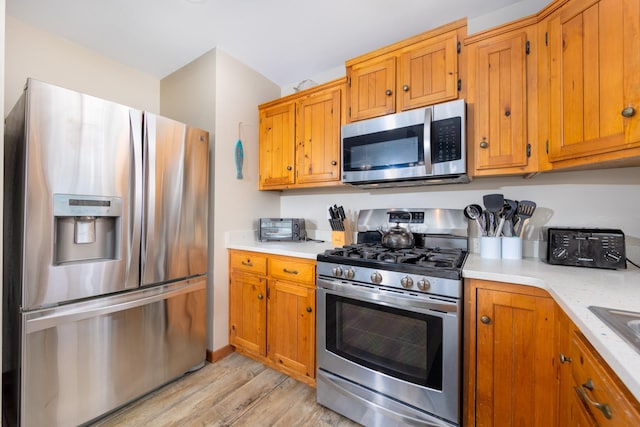 23180 Wimble Shores Dr Lot 8, Rodanthe, NC 27968 - kitchen with appliances with stainless steel finishes, light wood-style floors, light countertops, and brown cabinets