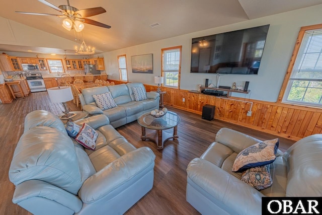 living area featuring wooden walls, visible vents, dark wood finished floors, a wainscoted wall, and vaulted ceiling