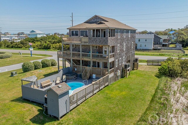 back of house with a fenced in pool, a patio, a balcony, roof with shingles, and fence