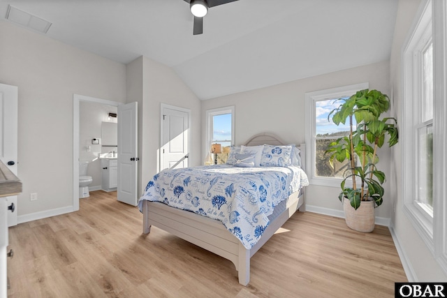 bedroom featuring visible vents, baseboards, lofted ceiling, and light wood finished floors