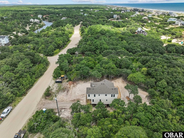 drone / aerial view featuring a view of trees and a water view