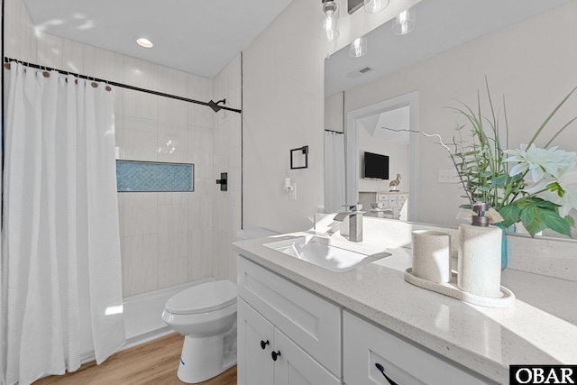 full bath featuring visible vents, toilet, a shower with curtain, wood finished floors, and vanity