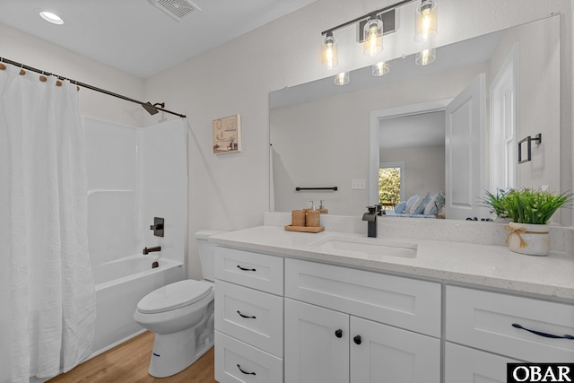 ensuite bathroom with visible vents, toilet, ensuite bathroom, wood finished floors, and vanity