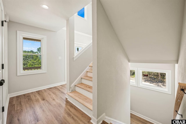 stairway with recessed lighting, wood finished floors, and baseboards