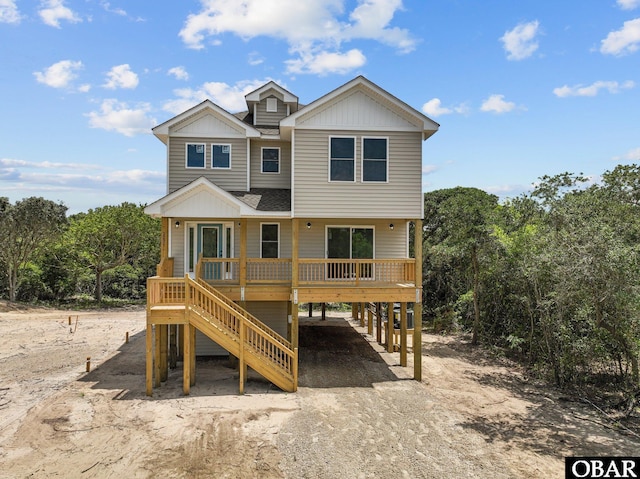 view of front of property with a carport, board and batten siding, driveway, and a shingled roof