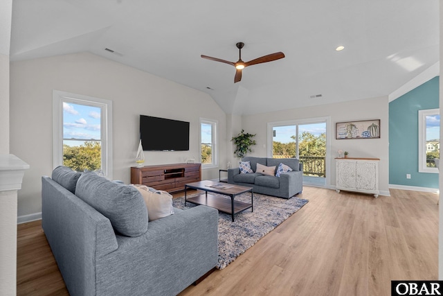 living room featuring wood finished floors, a ceiling fan, visible vents, baseboards, and vaulted ceiling