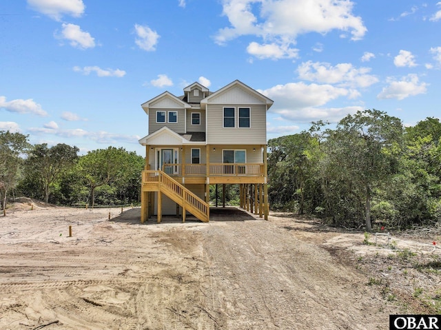 view of front of house featuring a carport, stairway, and driveway