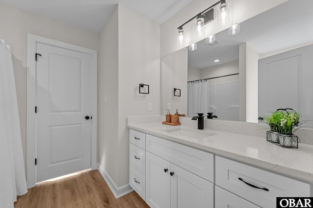 full bathroom featuring vanity, wood finished floors, visible vents, baseboards, and curtained shower