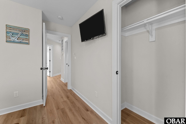 hallway with baseboards and light wood finished floors