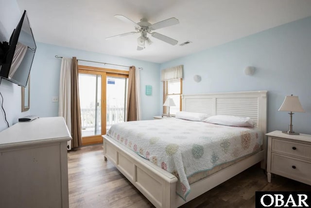 bedroom featuring access to exterior, a ceiling fan, visible vents, and dark wood-style floors