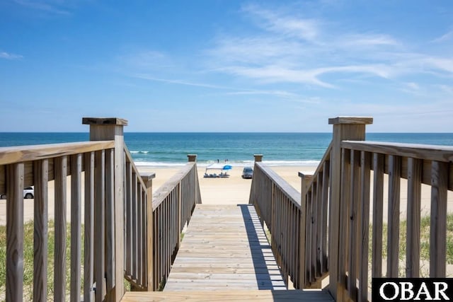 surrounding community featuring a water view and a beach view