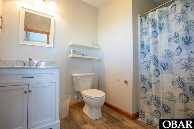 bathroom with baseboards, toilet, wood finished floors, curtained shower, and vanity