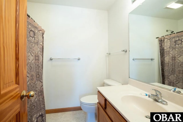 bathroom with baseboards, vanity, and toilet