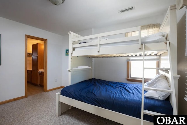 unfurnished bedroom featuring baseboards, visible vents, carpet flooring, and ensuite bathroom