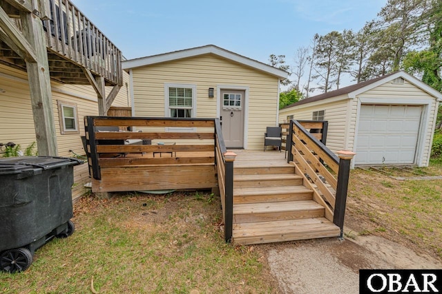 back of property featuring a wooden deck, a garage, and an outdoor structure