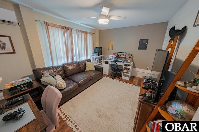 living room featuring wood finished floors, a desk, a wall unit AC, and ceiling fan