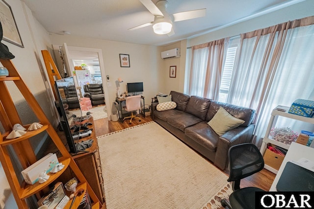 living area with a wall mounted AC, an office area, ceiling fan, and wood finished floors