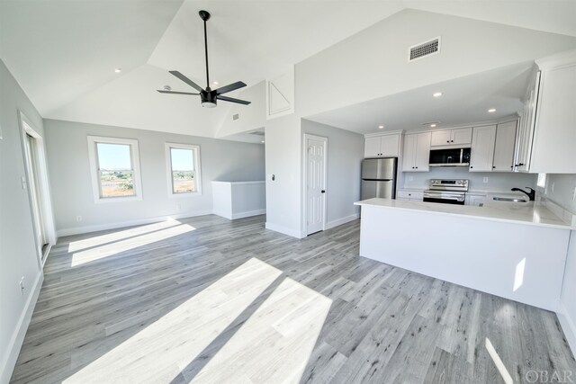 56185 Cedar Ave Lot 5, Hatteras, NC 27943 - kitchen with light countertops, appliances with stainless steel finishes, open floor plan, white cabinetry, and high vaulted ceiling