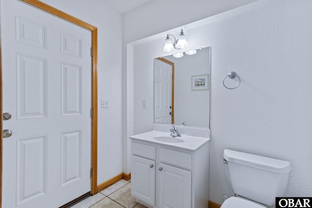 bathroom with baseboards, vanity, toilet, and tile patterned floors