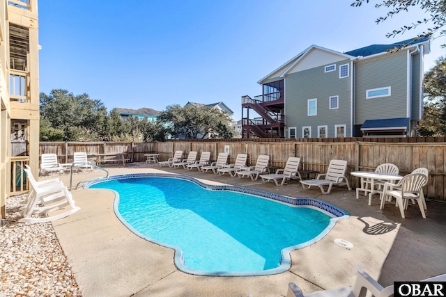 pool with a patio area and a fenced backyard