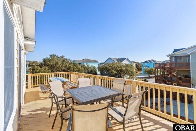 deck with outdoor dining space and a residential view