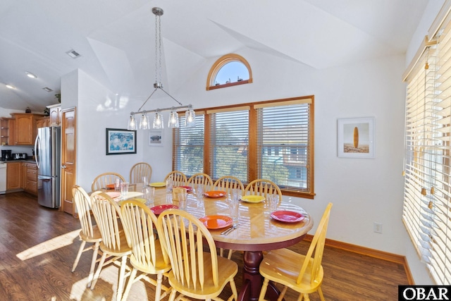 dining room featuring dark wood-style floors, visible vents, vaulted ceiling, and baseboards