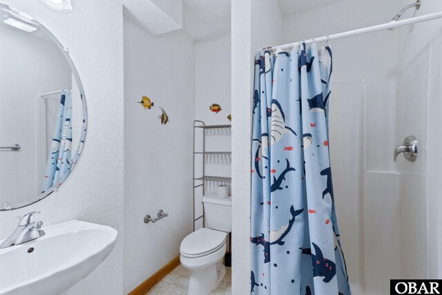 bathroom with toilet, baseboards, a sink, and a shower with shower curtain