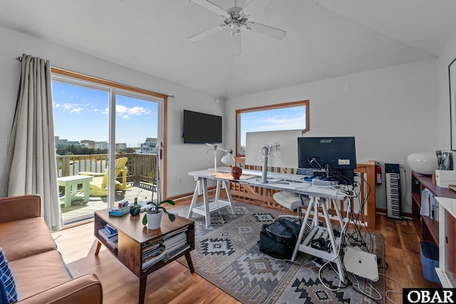 office featuring baseboards, ceiling fan, wood finished floors, and lofted ceiling