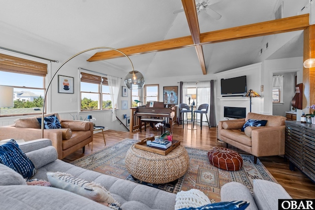 living room with vaulted ceiling with beams, a ceiling fan, plenty of natural light, and wood finished floors