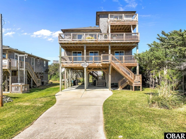 view of front of property featuring driveway, a front lawn, stairs, and a carport