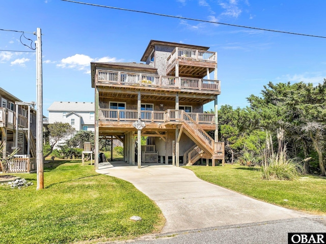 beach home with stairs, a deck, a front yard, a carport, and driveway