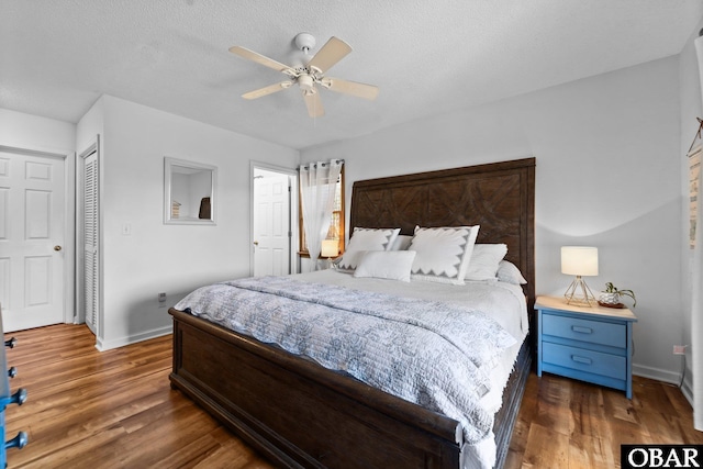 bedroom with baseboards, a ceiling fan, a closet, and wood finished floors