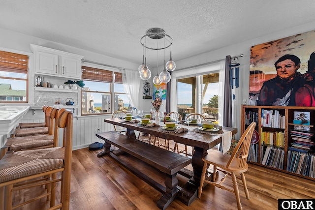 dining area featuring a textured ceiling, a wealth of natural light, and wood finished floors