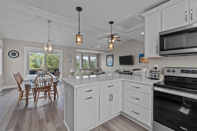 kitchen featuring lofted ceiling, stainless steel appliances, white cabinetry, open floor plan, and light countertops