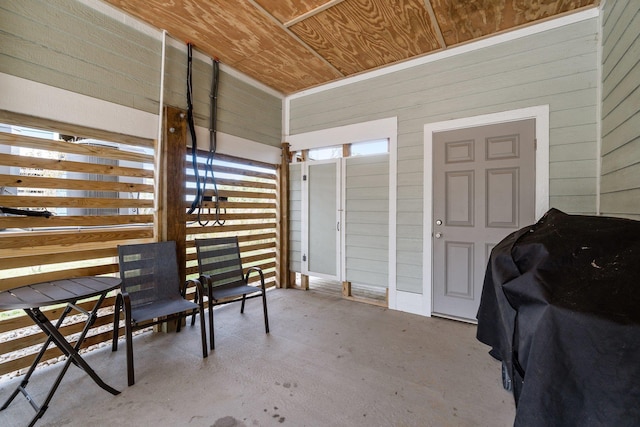 interior space with wood walls, wood ceiling, and concrete flooring