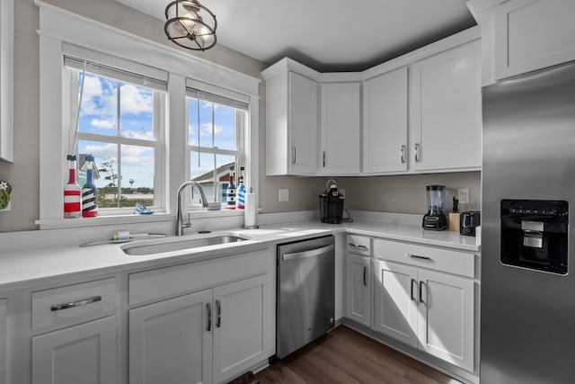 kitchen with stainless steel appliances, light countertops, a sink, and white cabinetry