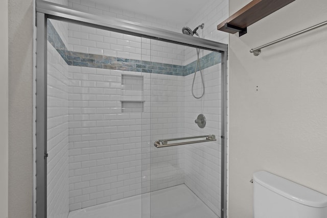 bathroom featuring a shower stall and toilet