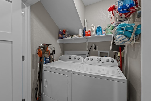 washroom featuring a textured wall and washer and dryer