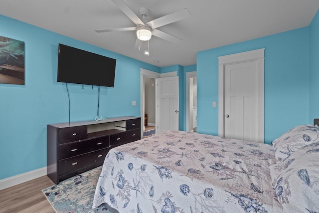 bedroom with light wood-style floors, baseboards, and a ceiling fan