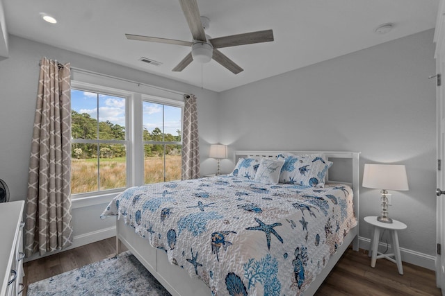 bedroom with ceiling fan, dark wood-type flooring, visible vents, and baseboards