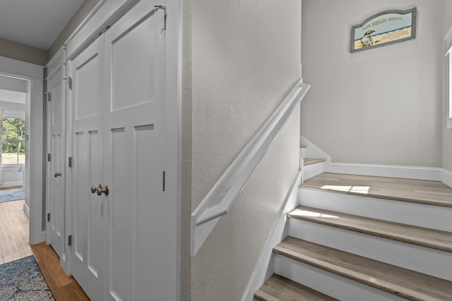 staircase featuring baseboards and wood finished floors