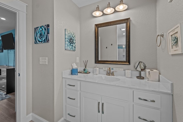 bathroom featuring vanity, baseboards, and wood finished floors