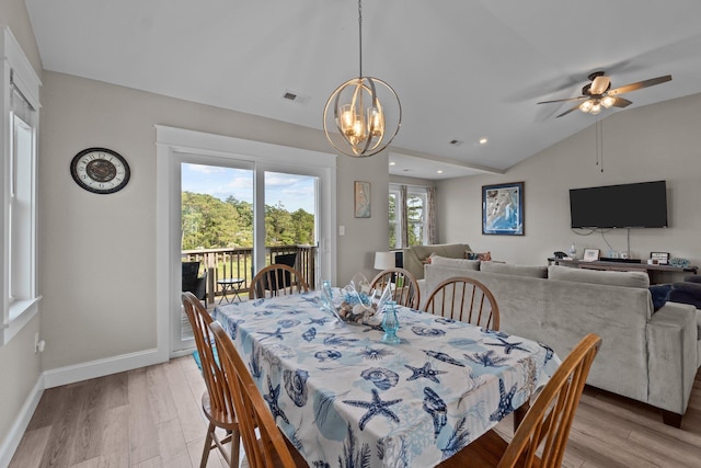 dining space featuring a chandelier, baseboards, vaulted ceiling, and light wood finished floors