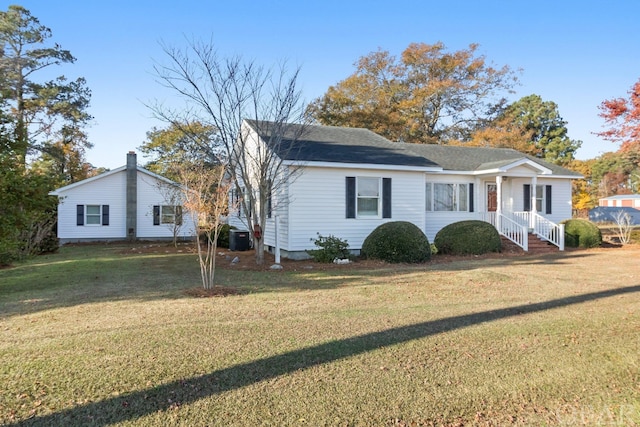 view of front of house with a front lawn and cooling unit