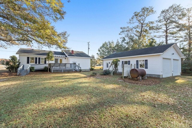 back of house featuring an outdoor structure, a yard, a deck, and heating fuel