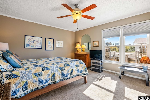 bedroom with a textured ceiling, carpet floors, baseboards, and crown molding