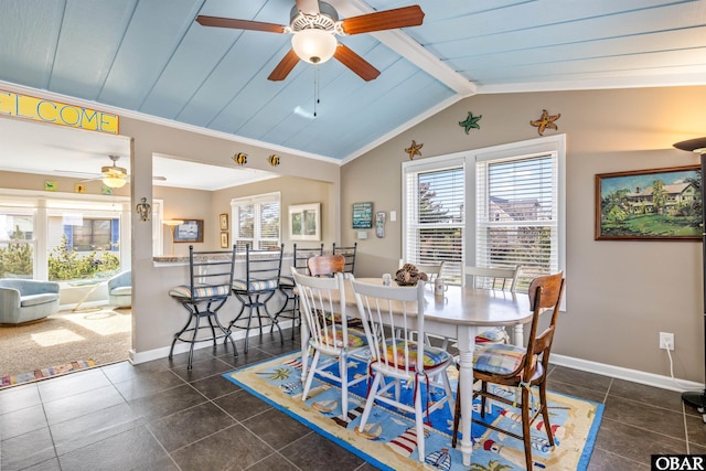 dining space featuring lofted ceiling with beams, baseboards, and a wealth of natural light