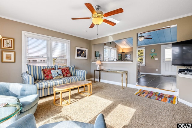 living area with a wealth of natural light, baseboards, crown molding, and dark colored carpet